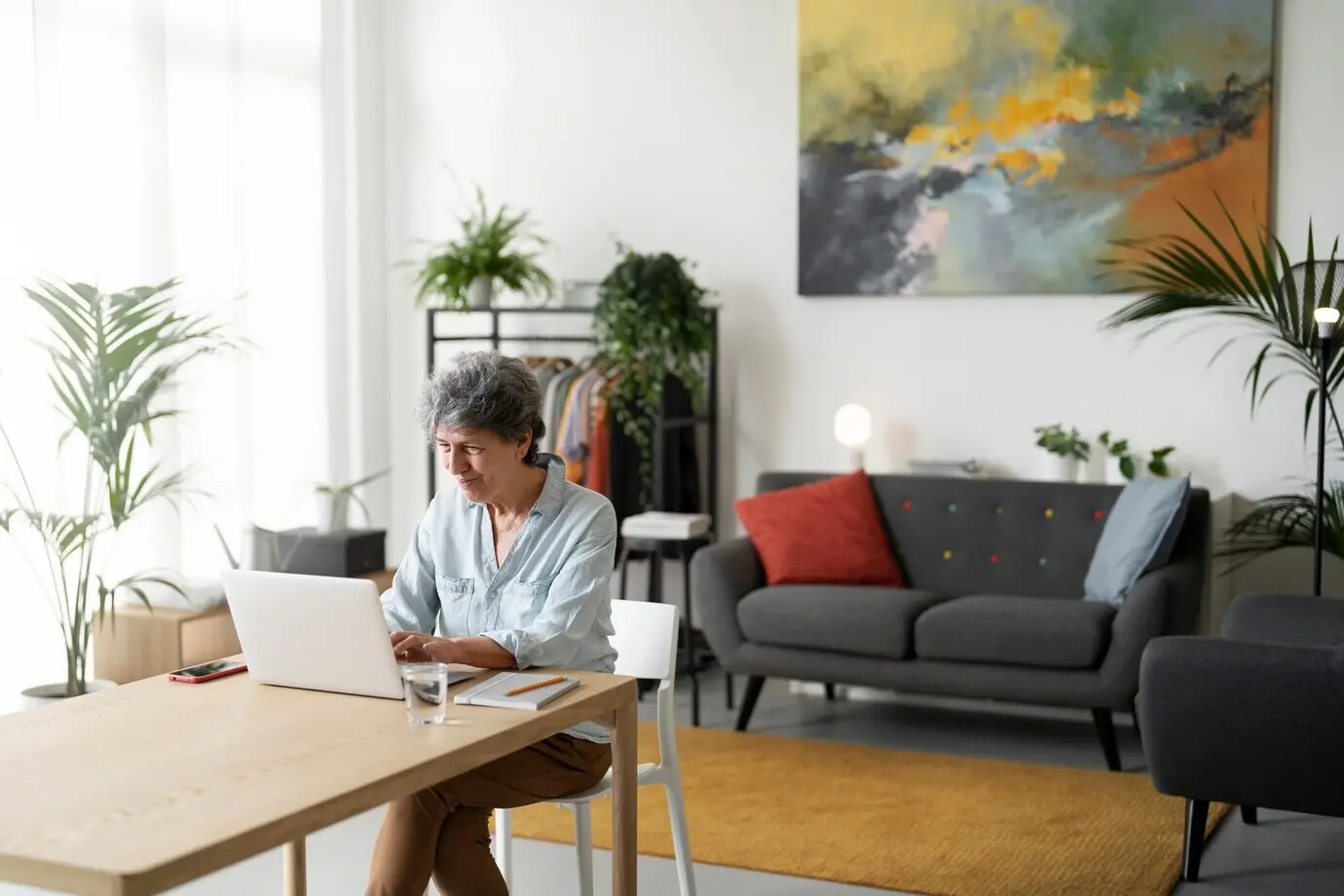 Halbnahe Aufnahme einer alten Frau, die an einem Laptop arbeitet.